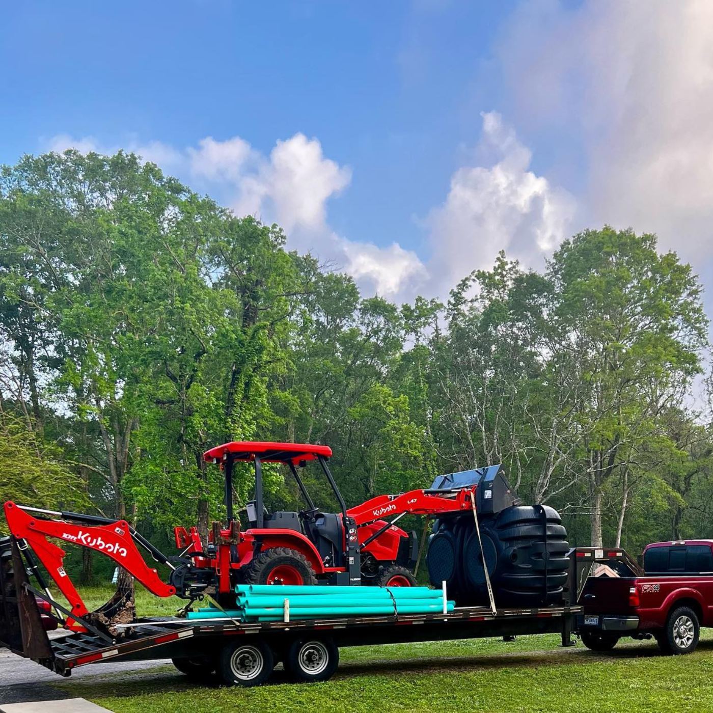 Kubota excavator and drain pipe on a trailer